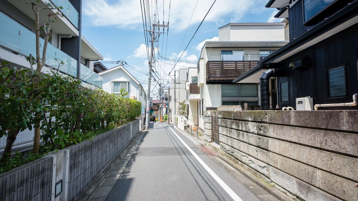 嫌悪施設を考える住宅街の通りと電柱の街並み